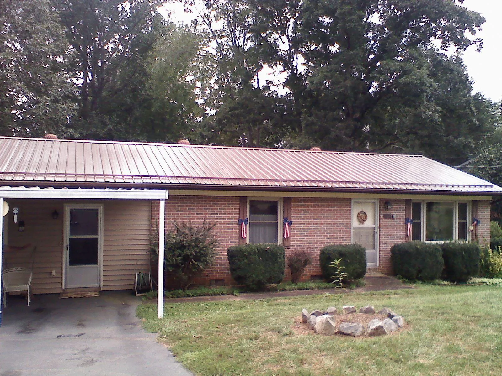 Bronze metal roof and carport on a brick ranch home — Roof Repair work by our crew in Nixon