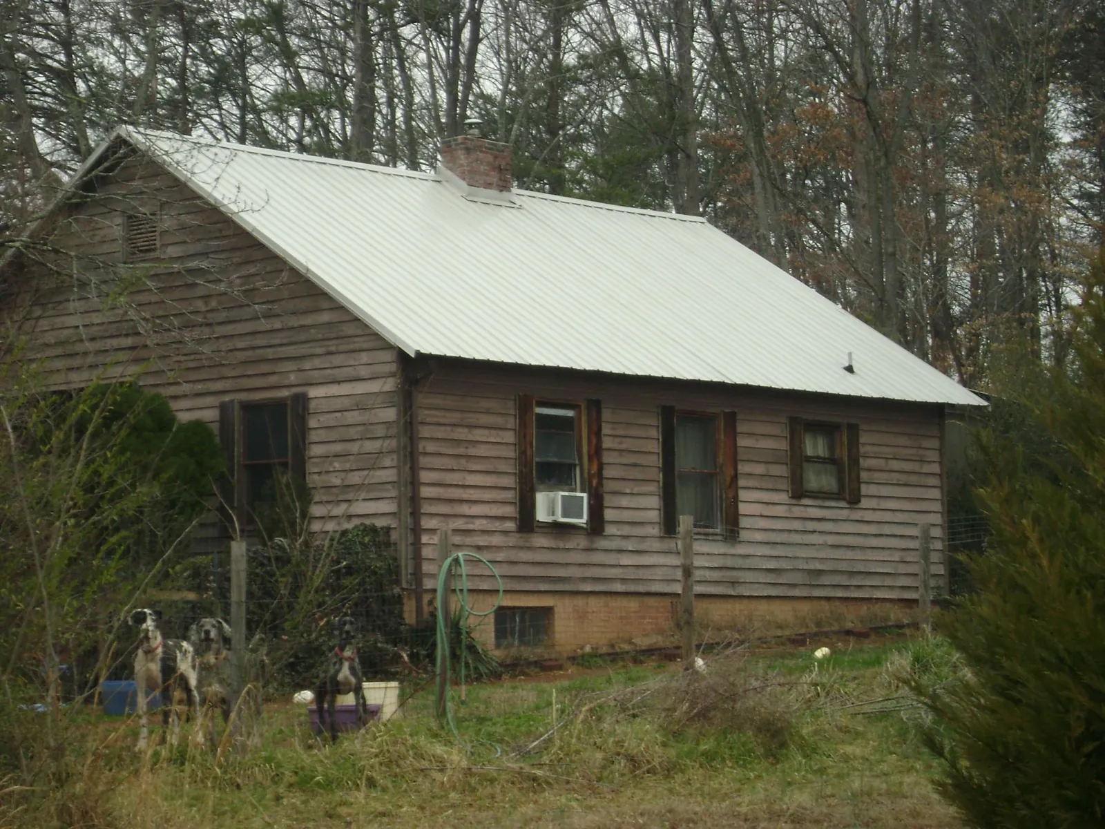 White metal roof on an old wood sided farmhouse, from a Metal Roof Installation job in Nixon