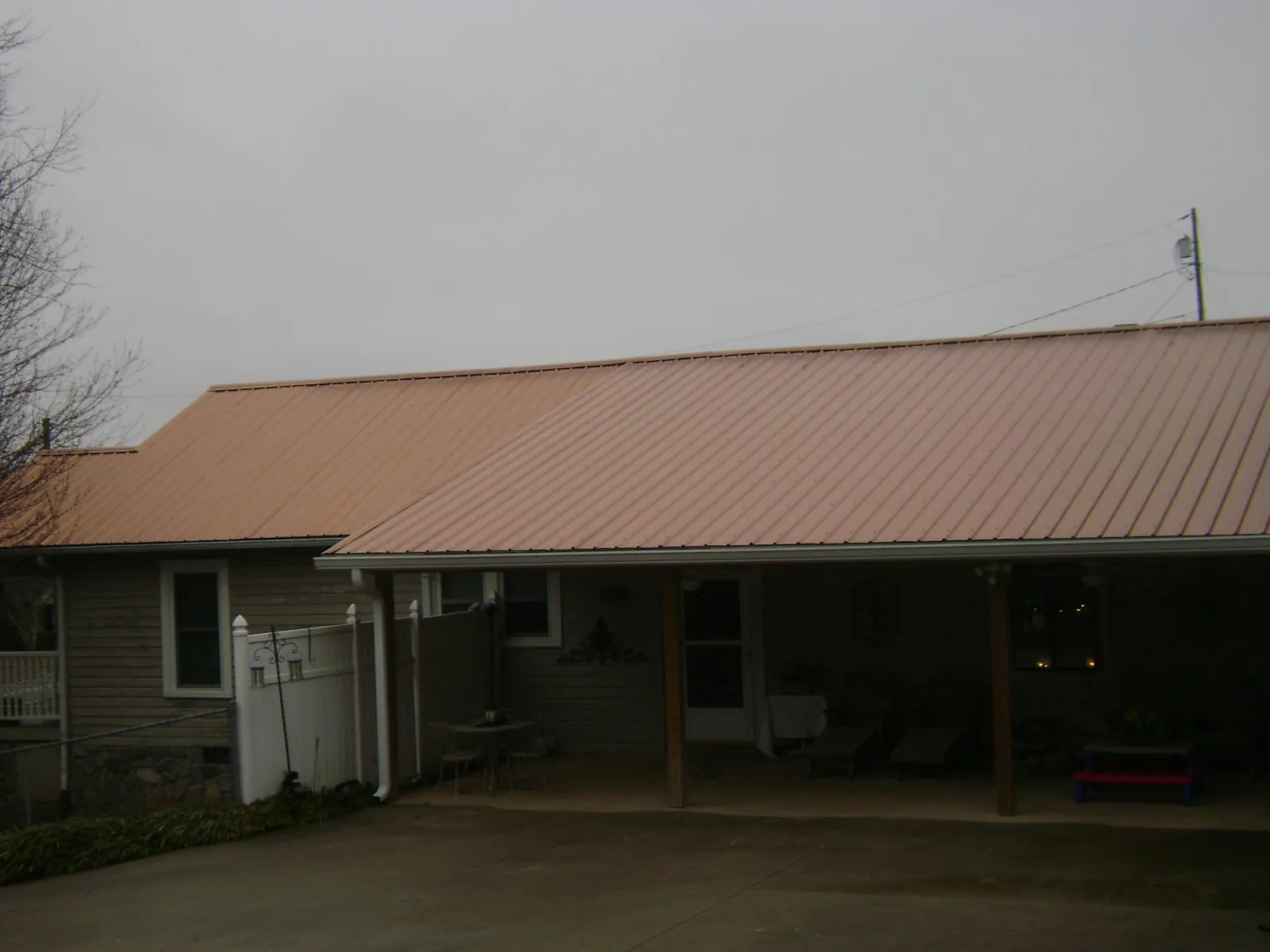 Copper toned metal roof over a wide covered patio in Nixon